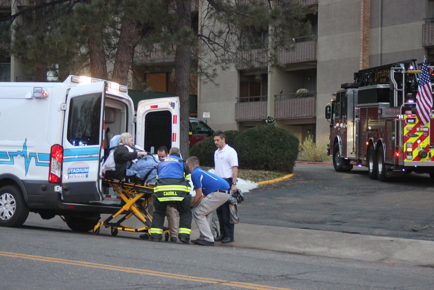 Paramedics load a woman into an ambulance after an early morning fire at the Windermere apartments at 5820 S. Datura St. on Nov 17. At least 13 people were injured. Photo by David Gilbert